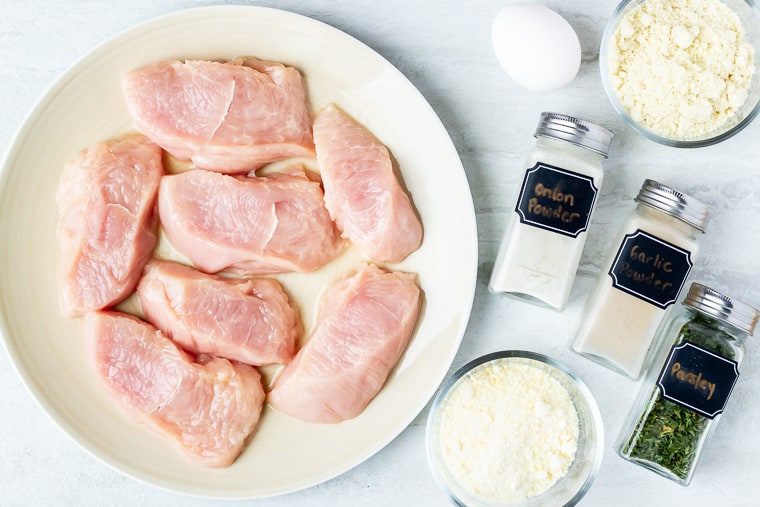 Ingredients need to make parmesan crusted turkey cutlets on a white background
