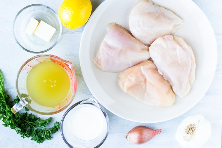 Ingredients needed to make Lemon Garlic Chicken sitting out over a white background