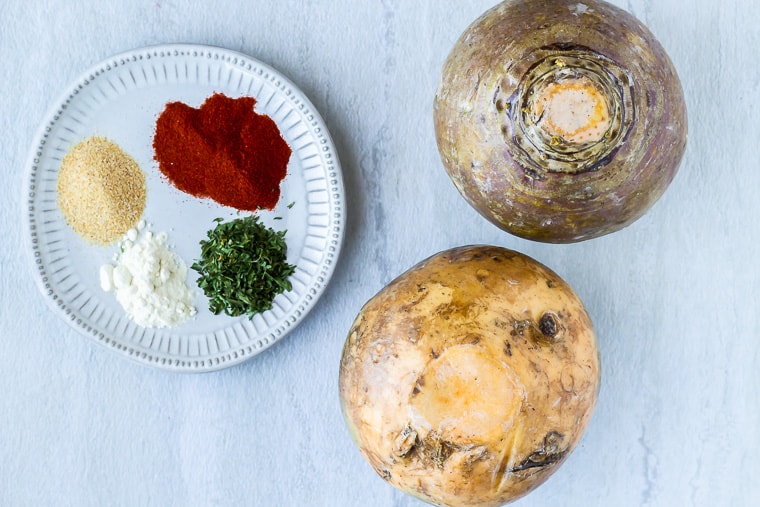 Ingredients needed to make seasoned rutabaga fries on a white background