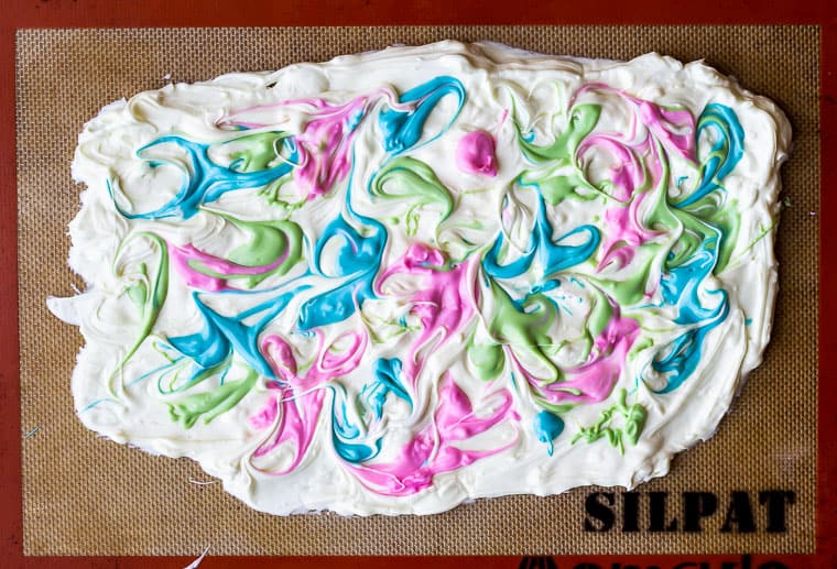 Melted white chocolate spread onto a silpat mat and topped with swirls of melted candy melts