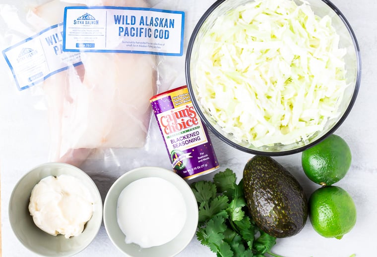 Ingredients needed to make blackened fish tacos on a white background
