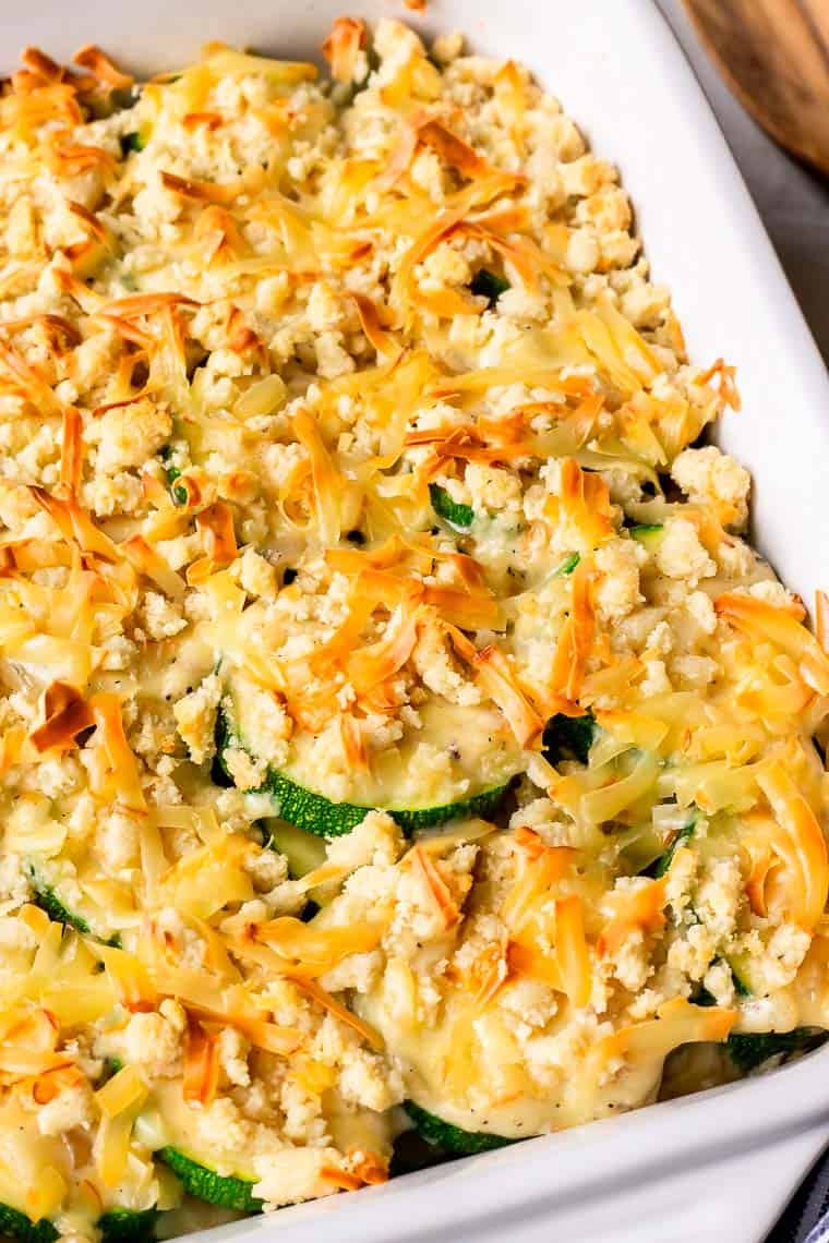 Close up of a baked zucchini gratin in a white casserole dish