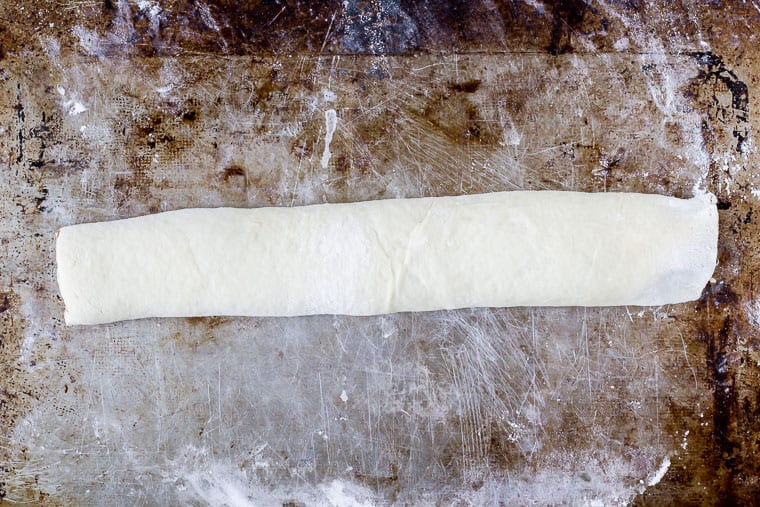 Babka dough rolled into a log on a baking sheet