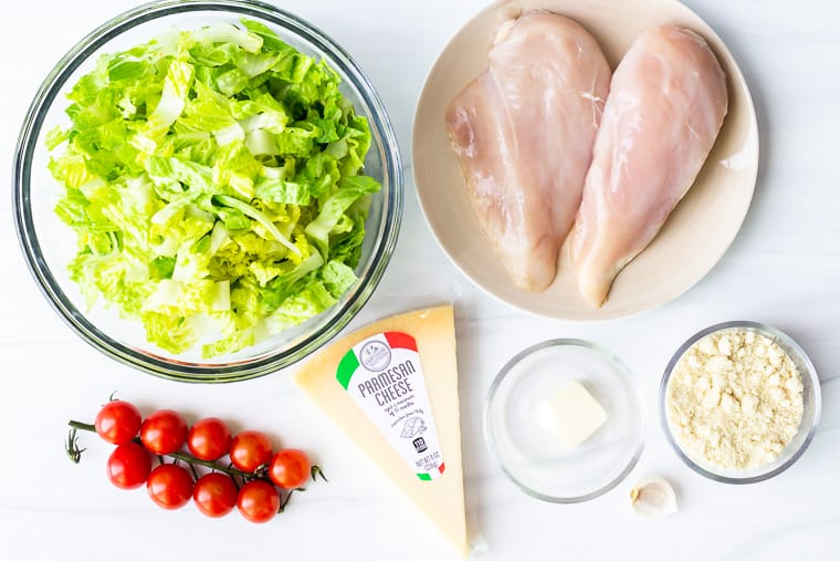 Ingredients to make a keto caesar salad on a white background