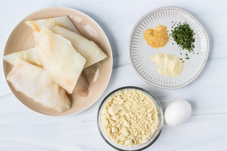 Ingredients to make pan-fried cod on a white background