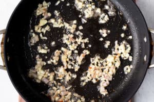 Garlic and Shallots cooking in a black skillet