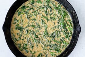 Spinach in a creamy sauce in a cast iron skillet