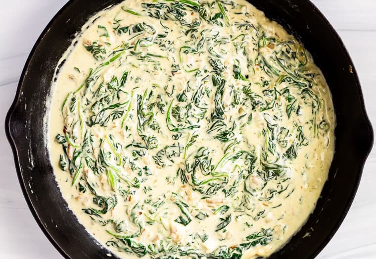 Creamed spinach in a black cast iron skillet