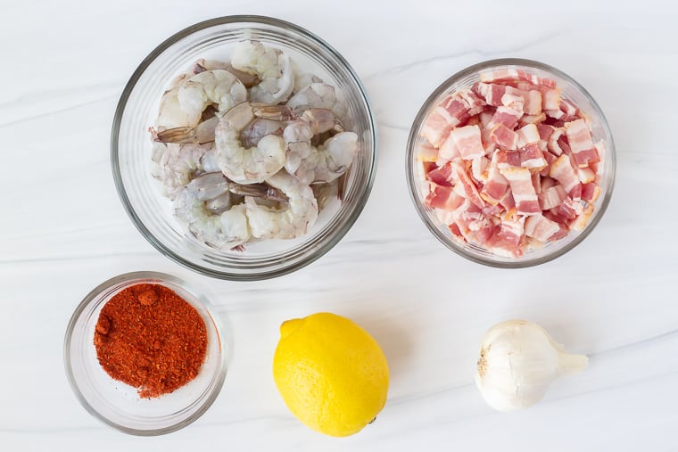 Ingredients to make Cajun shrimp on a white background