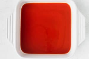 Enchilada sauce covering the bottom of a baking dish