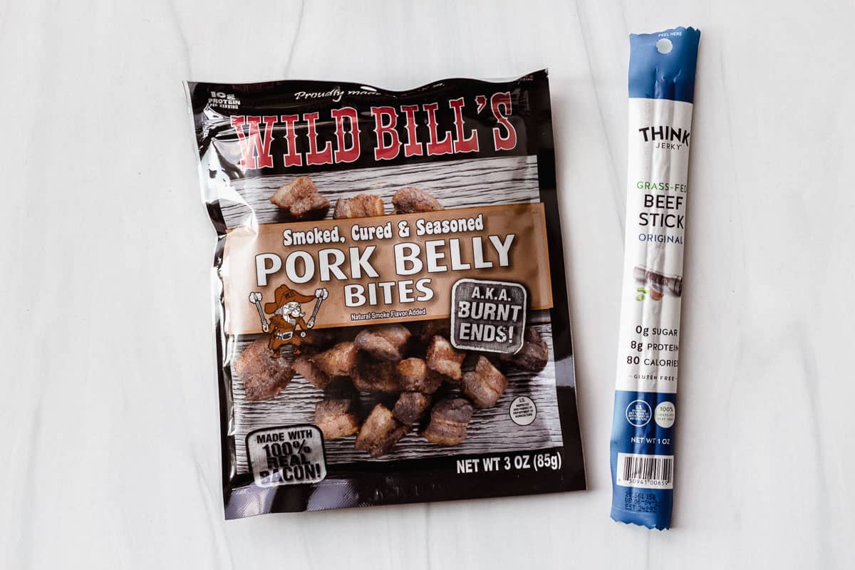 Wild Bill's pork belly bites and think jerky meat stick on a white background