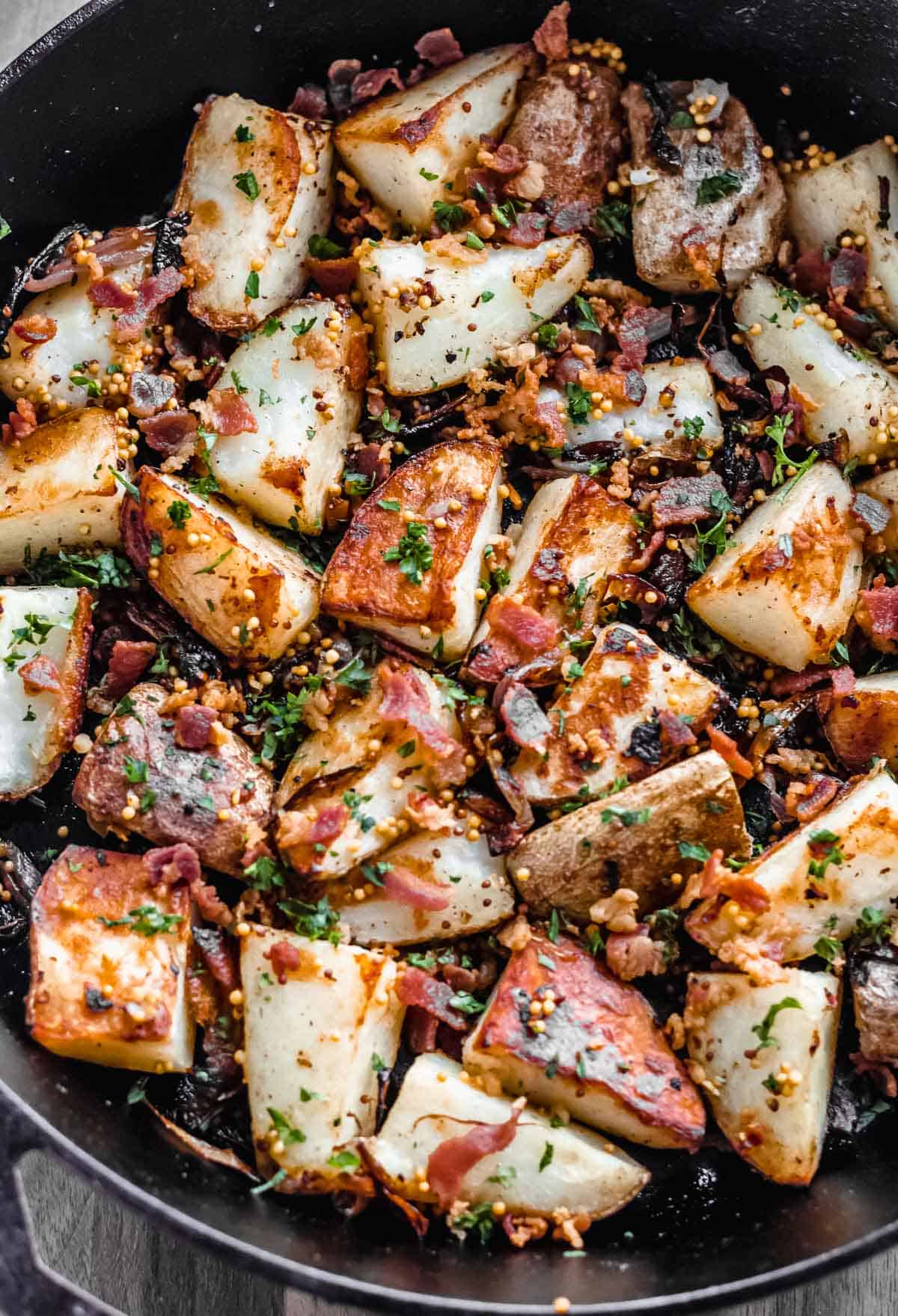 Close up of bacon roasted potatoes with caramelized shallots and parsley