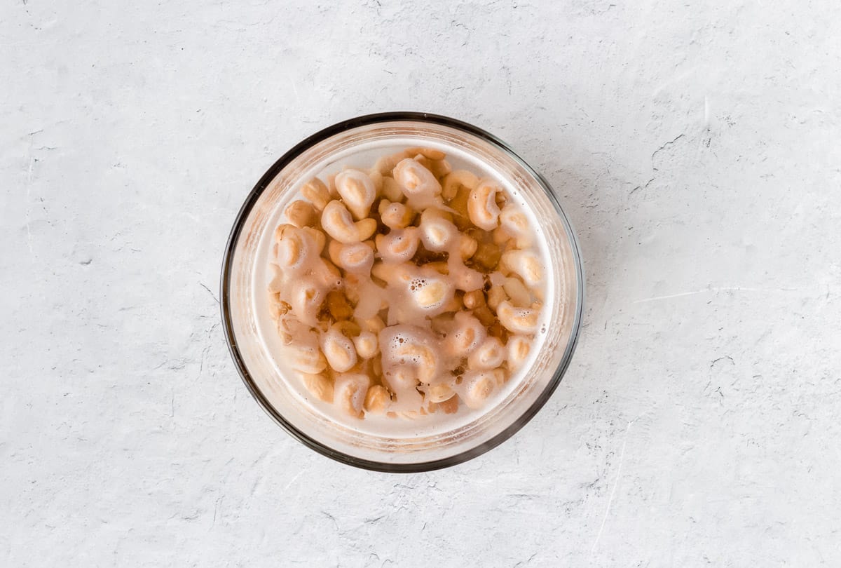 Cashews and hot water in a glass bowl on a white background