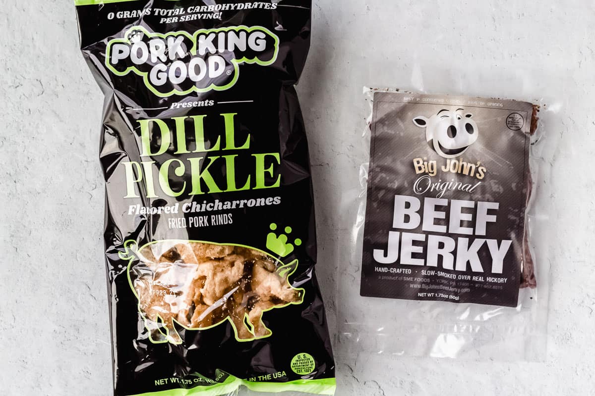 A bag of pork rinds and a bag of beef jerky on a white background