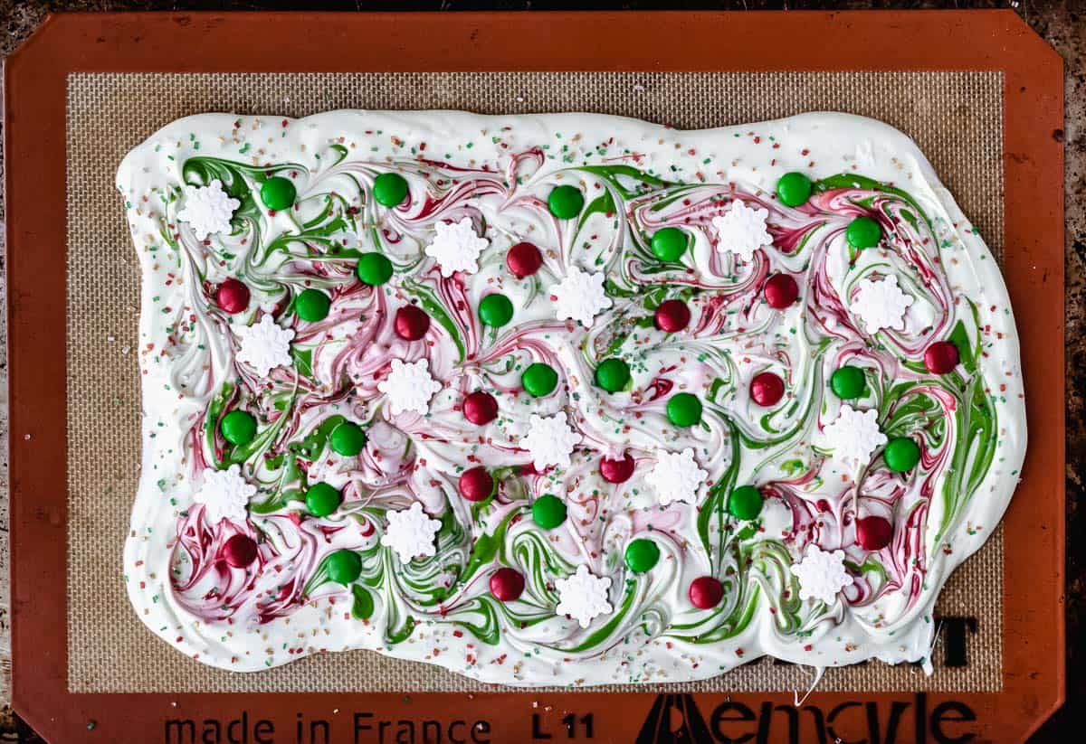 Melted white chocolate covered with swirls of melted red and green candy melts, m&m's and sprinkles