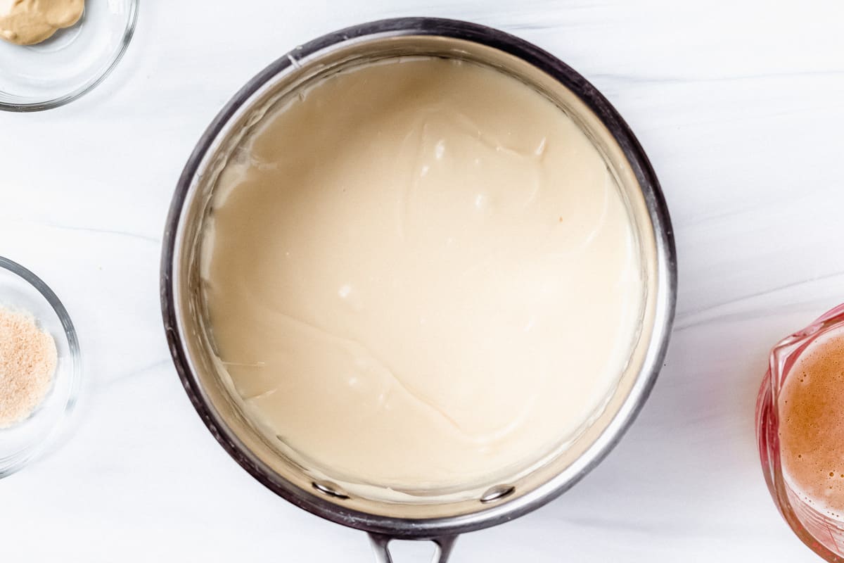 White cheddar cheese and cream cheese melted together in a silver sauce pan