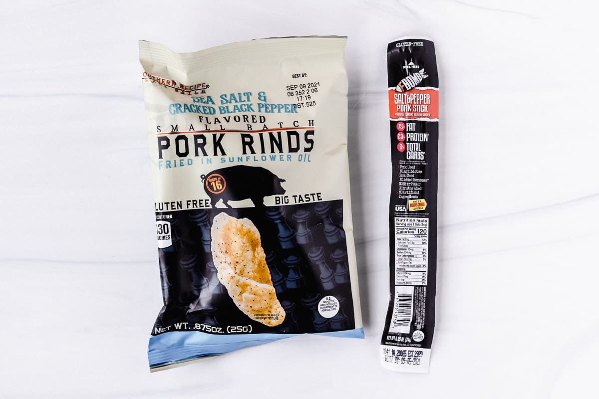 Pork rinds bag and a meat stick on a white background