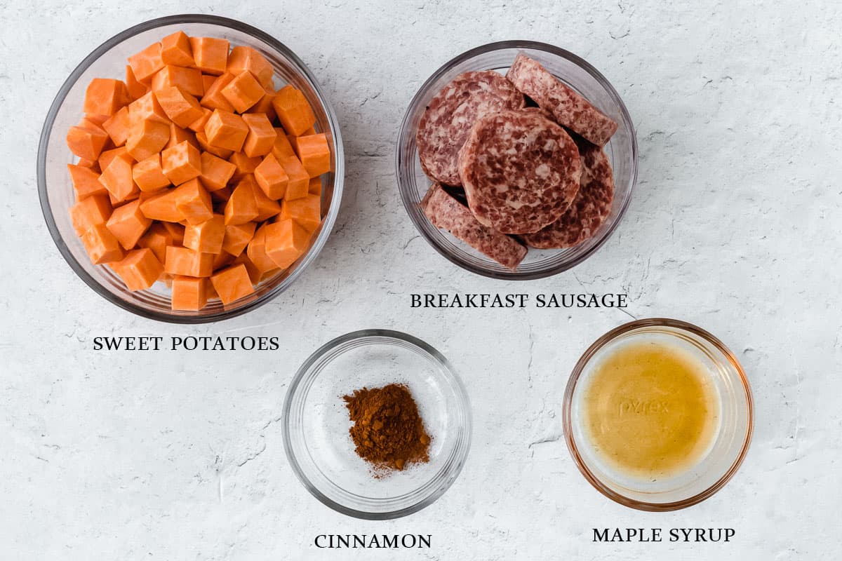 Ingredients to make maple sausage sweet potato hash on a white background with labels