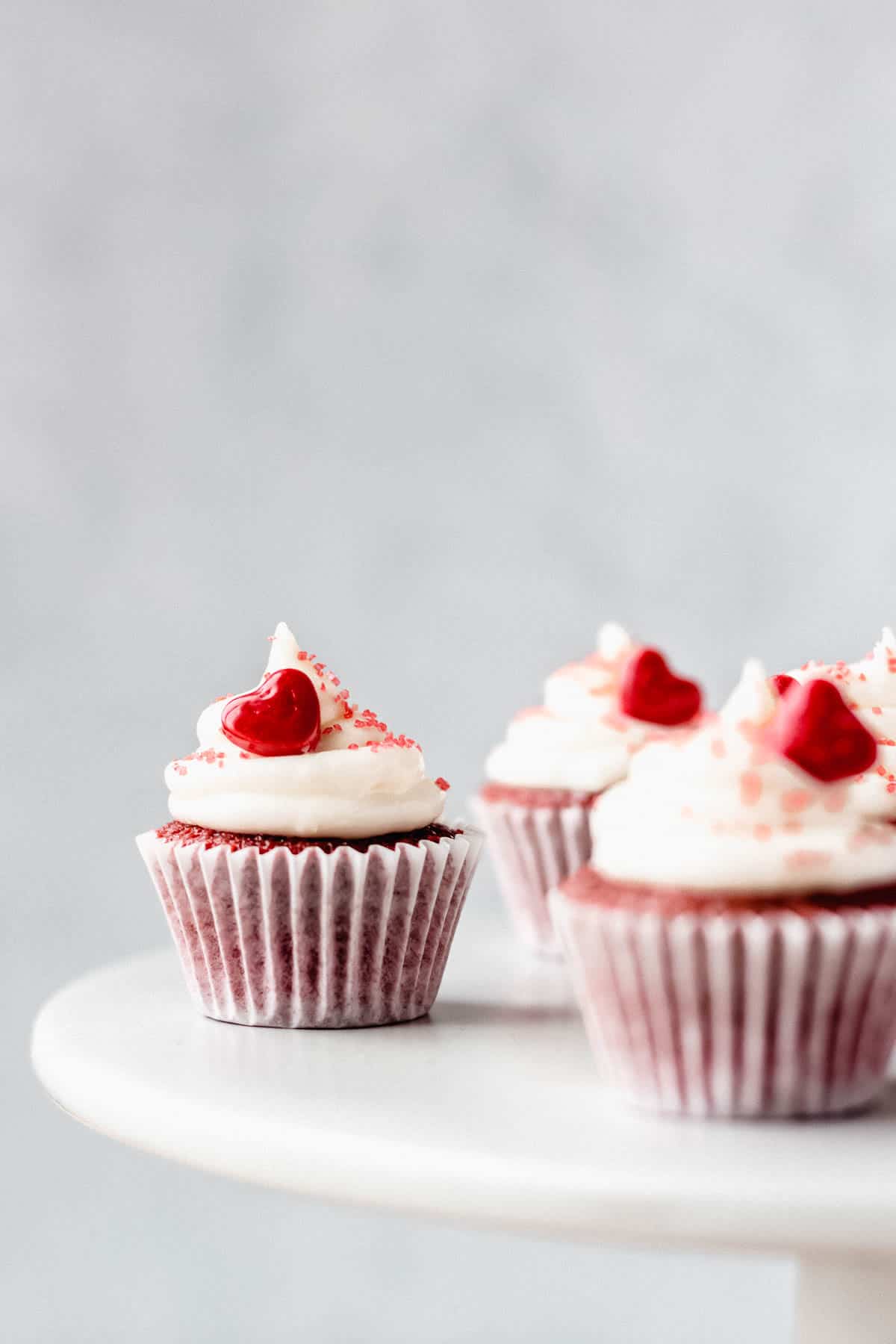 Mini Red Velvet Cupcakes on a white cake stand with a gray background