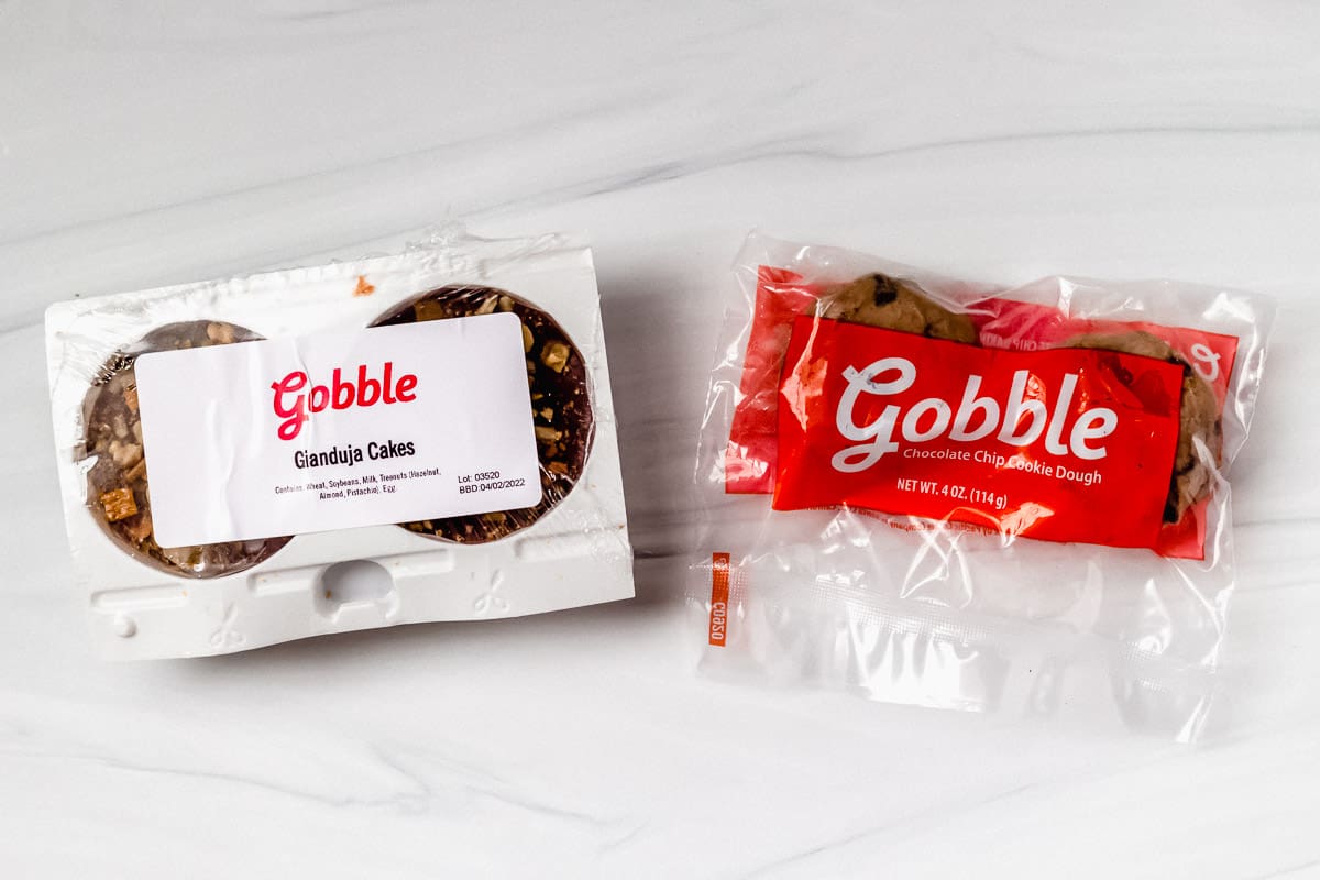 Cakes and chocolate chip cookie dough in packaging on a white background