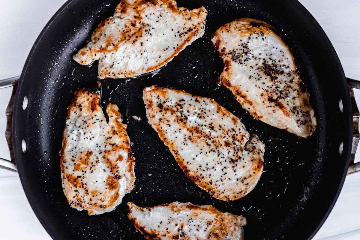 5 Sauteed chicken breasts in a black skillet 
