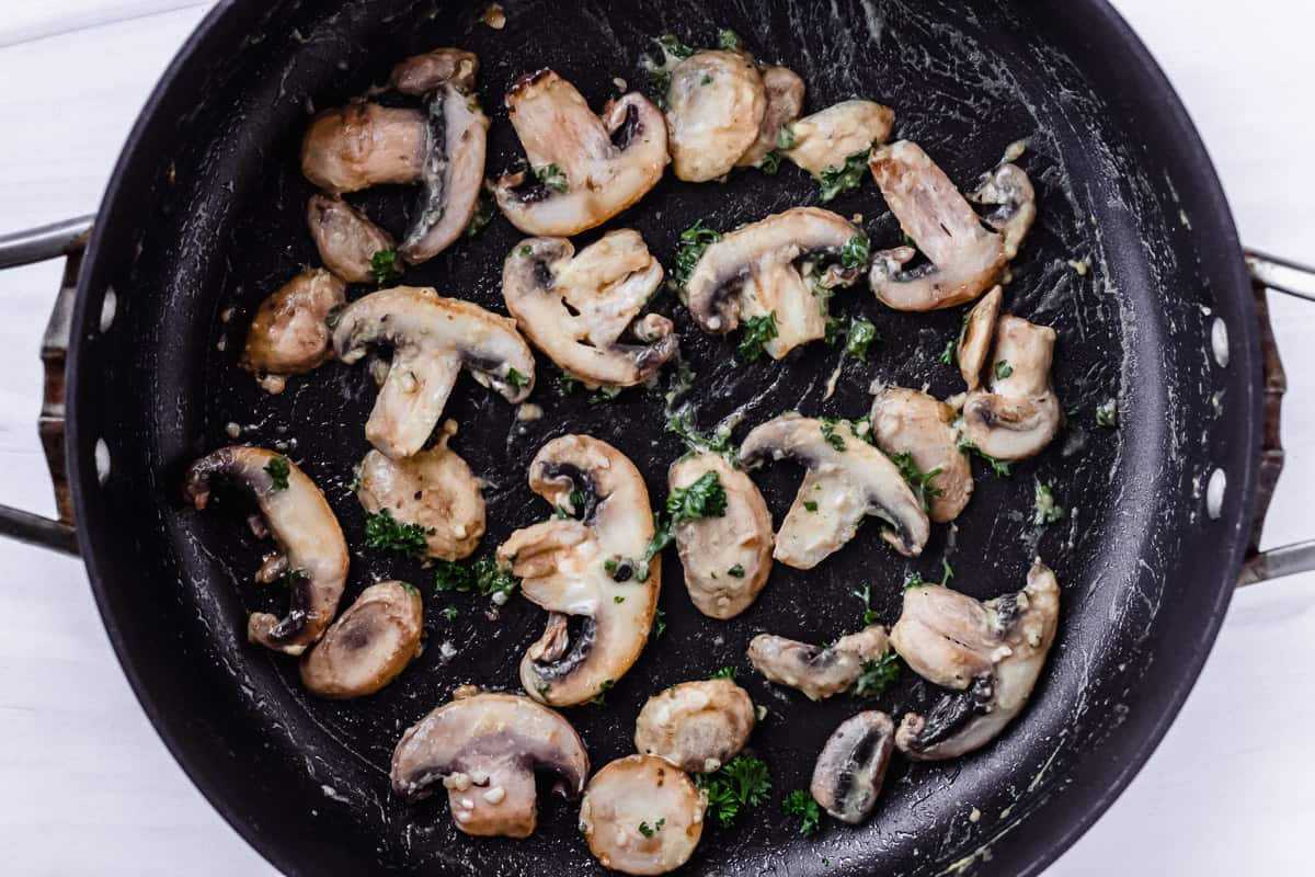 Mushrooms and herbs in a black skillet