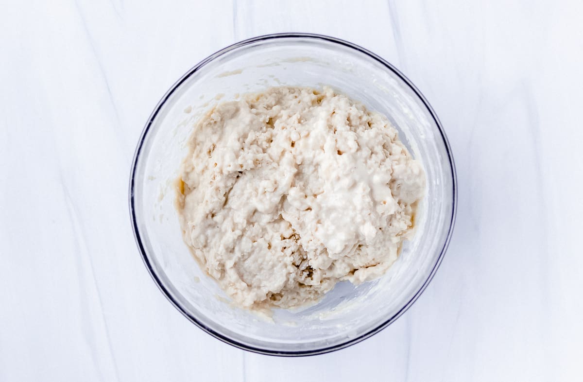 Cobbler dough batter in a glass bowl over a white background