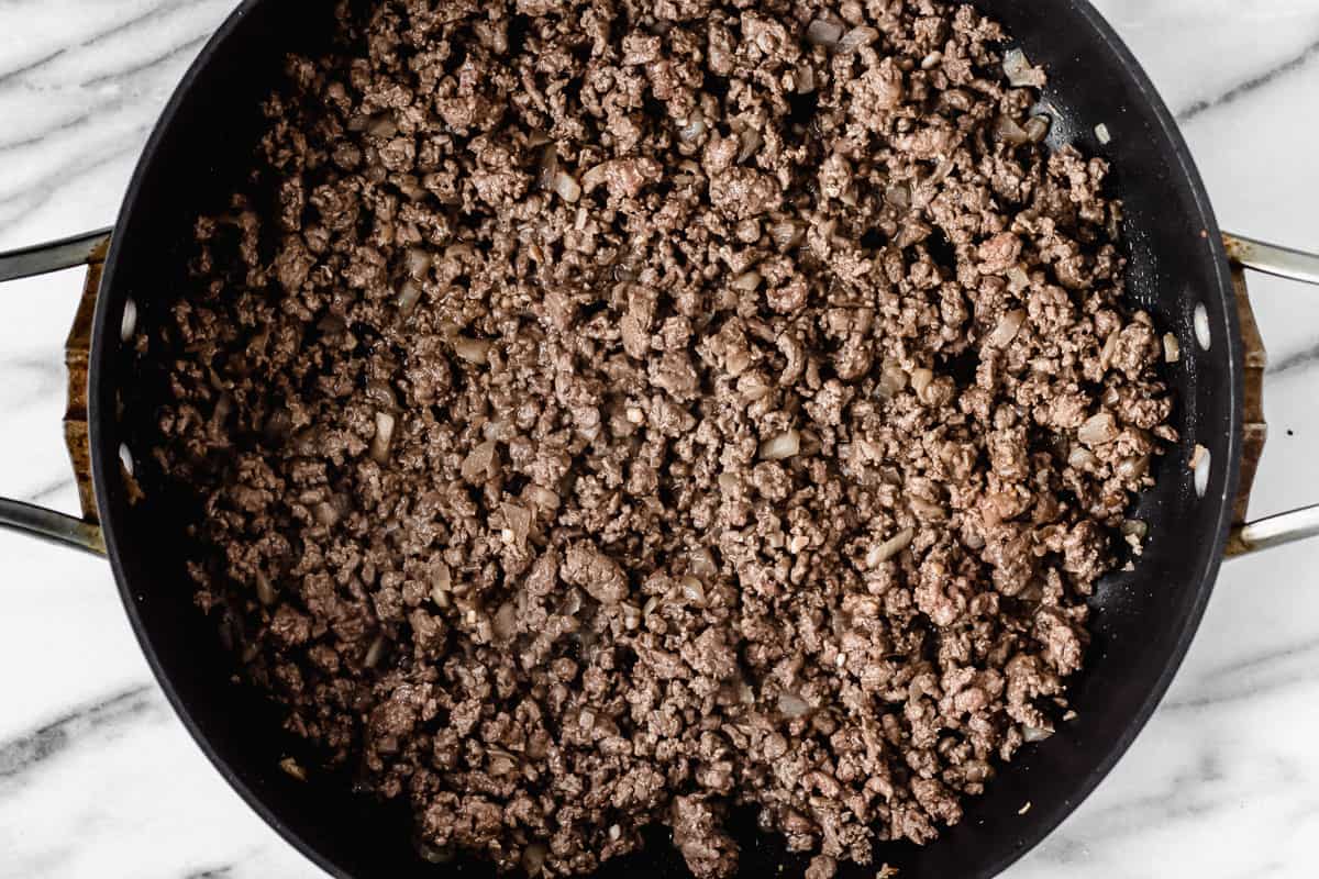 Cooked ground beef in a black skillet
