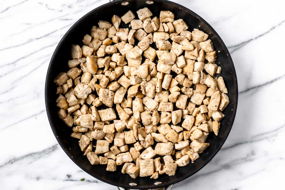 Cooked pieces of chicken in a black skillet