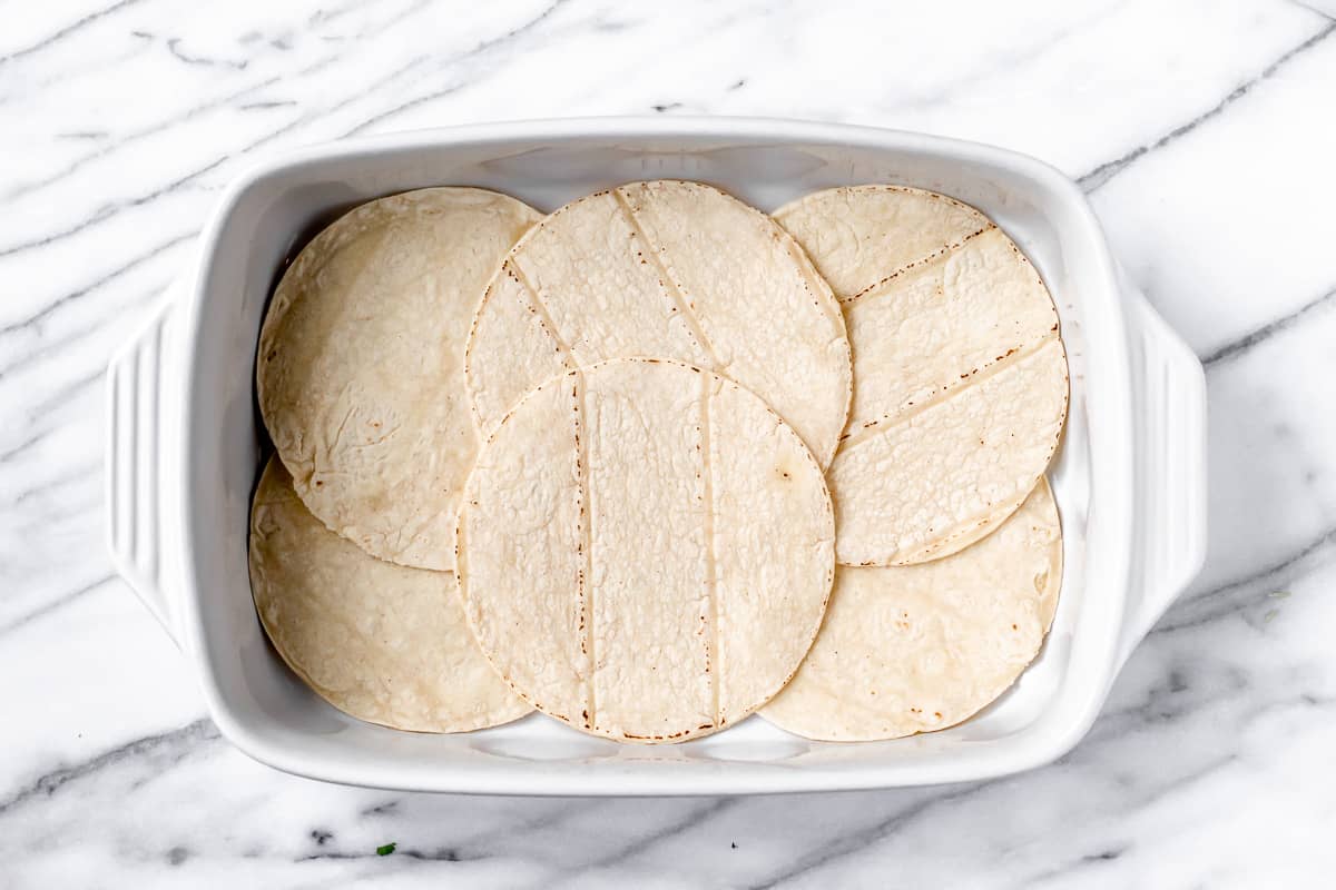 6 corn tortillas lining the bottom of a baking dish