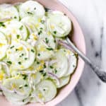 Overhead of a bowl of keto creamy cucumber salad with a spoon in it