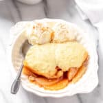 Pear cobbler and ice cream in a bowl with a spoon
