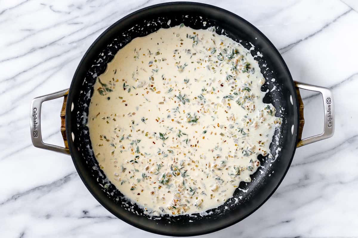 Shallot, garlic and heavy cream in a black skillet