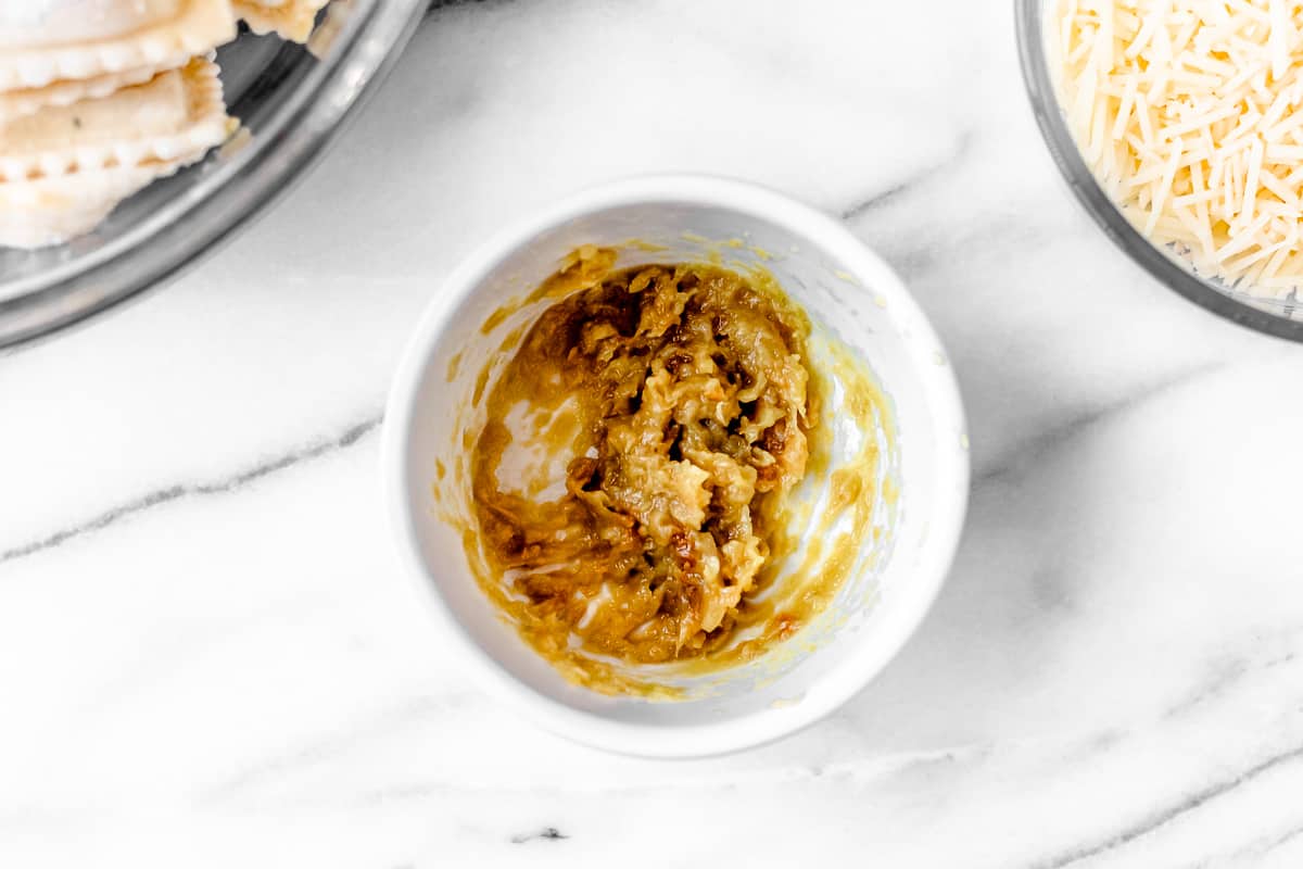 Mashed roasted garlic paste in a white bowl