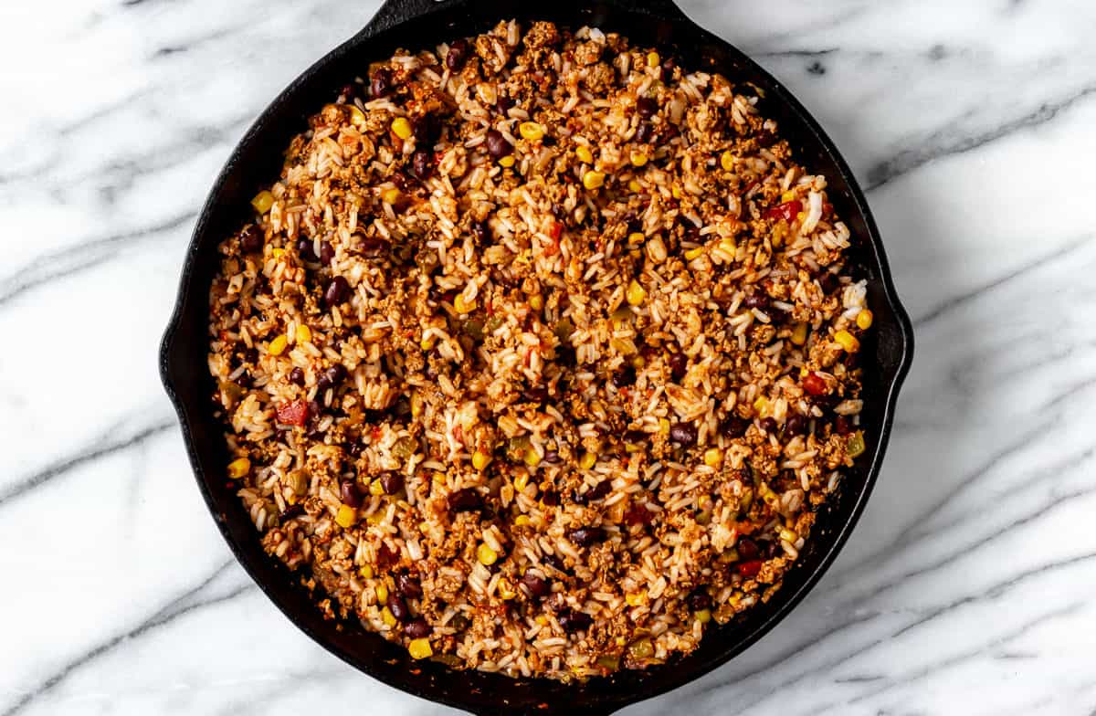 Seasoned turkey, rice, black beans, corn and salsa in a cast iron skillet