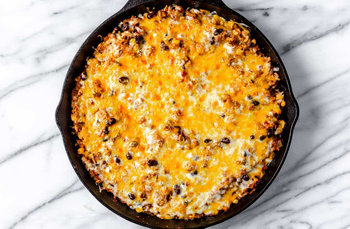 Cheesy Taco Skillet in a cast iron pan over a marble background