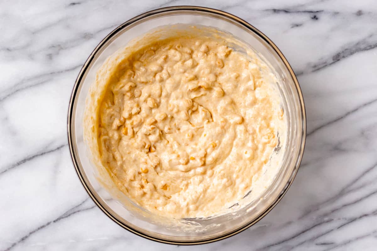 Corn soufflé batter in a glass bowl on a marble background