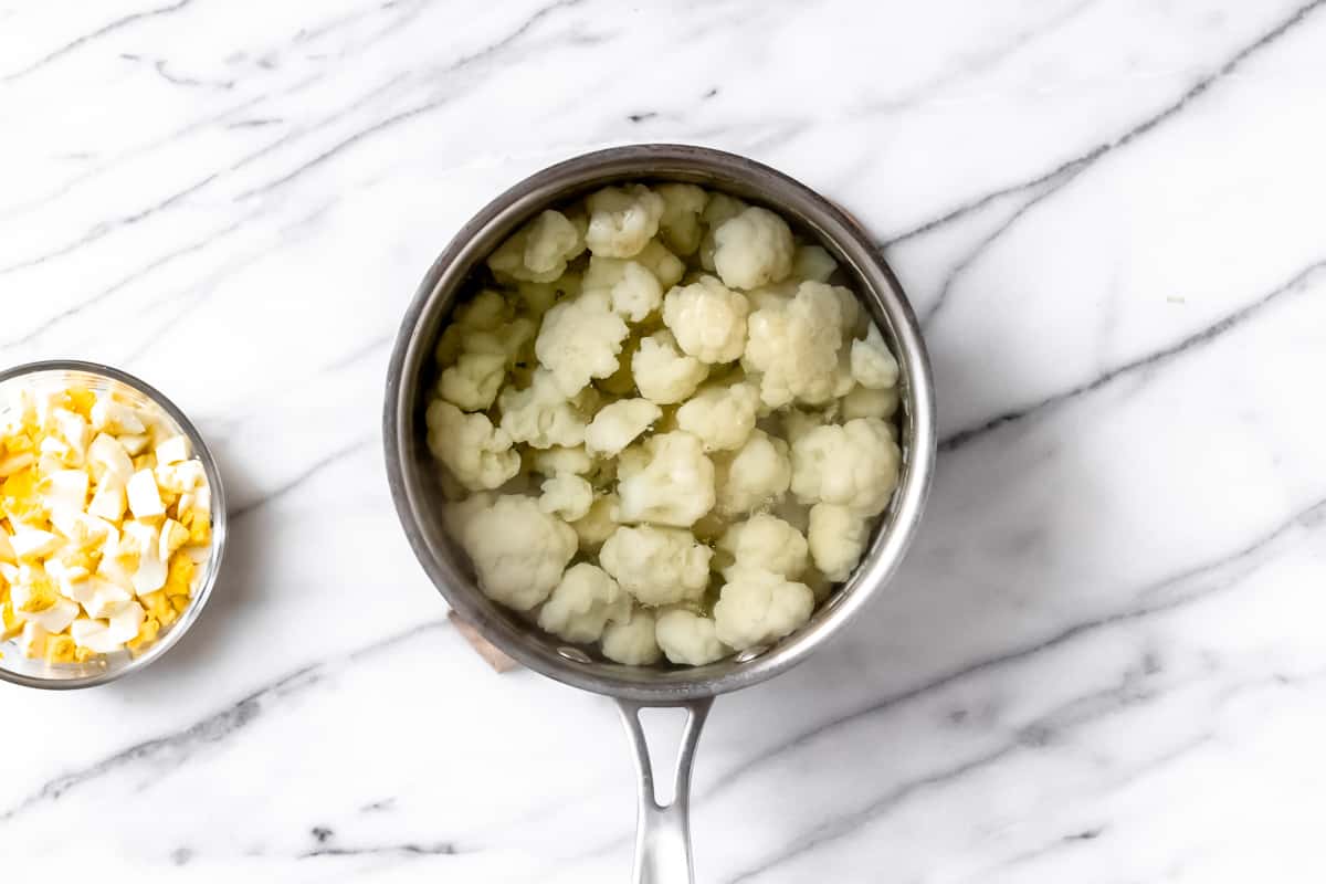 Cauliflower in a pot of water over a marble background