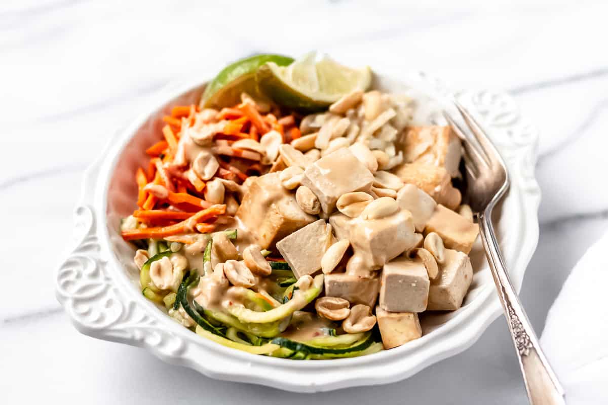 Sprinly Zucchini Noodle Pad Thai with Baked Tofu prepared and plated in a white bowl