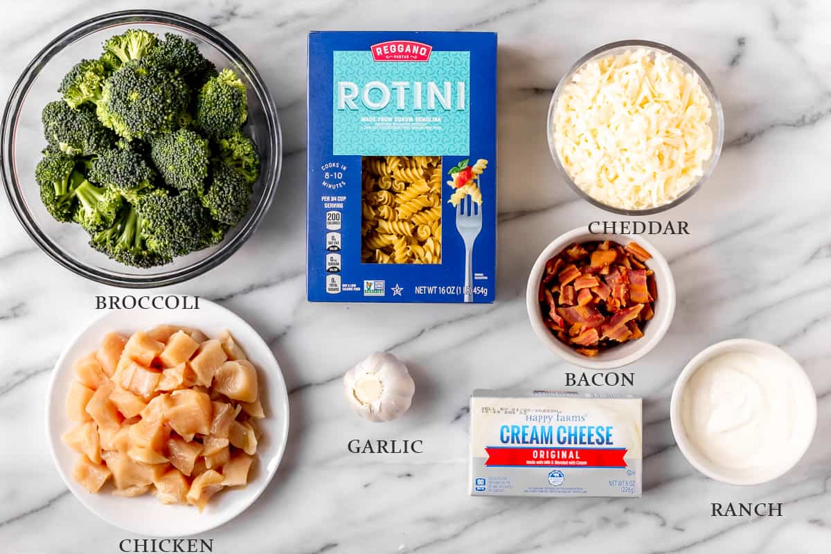 Ingredients to back chicken bacon ranch pasta on a marble background with text overlay
