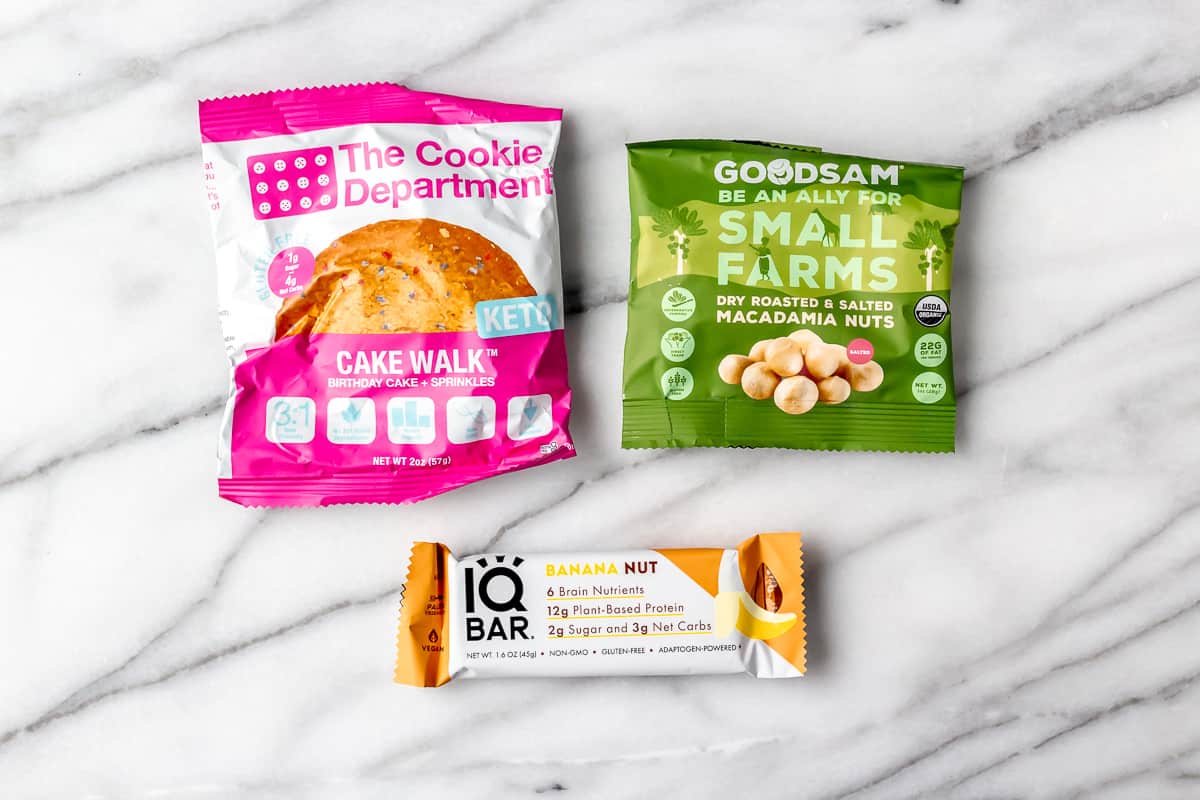 A keto cookie, macadamia nuts and a keto bar in packages