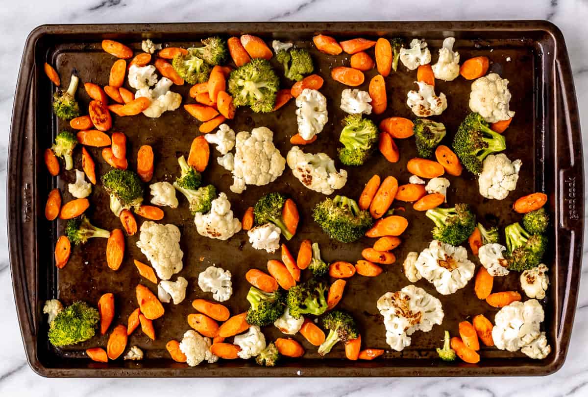Roasted broccoli, carrots, and cauliflower on a sheet pan.