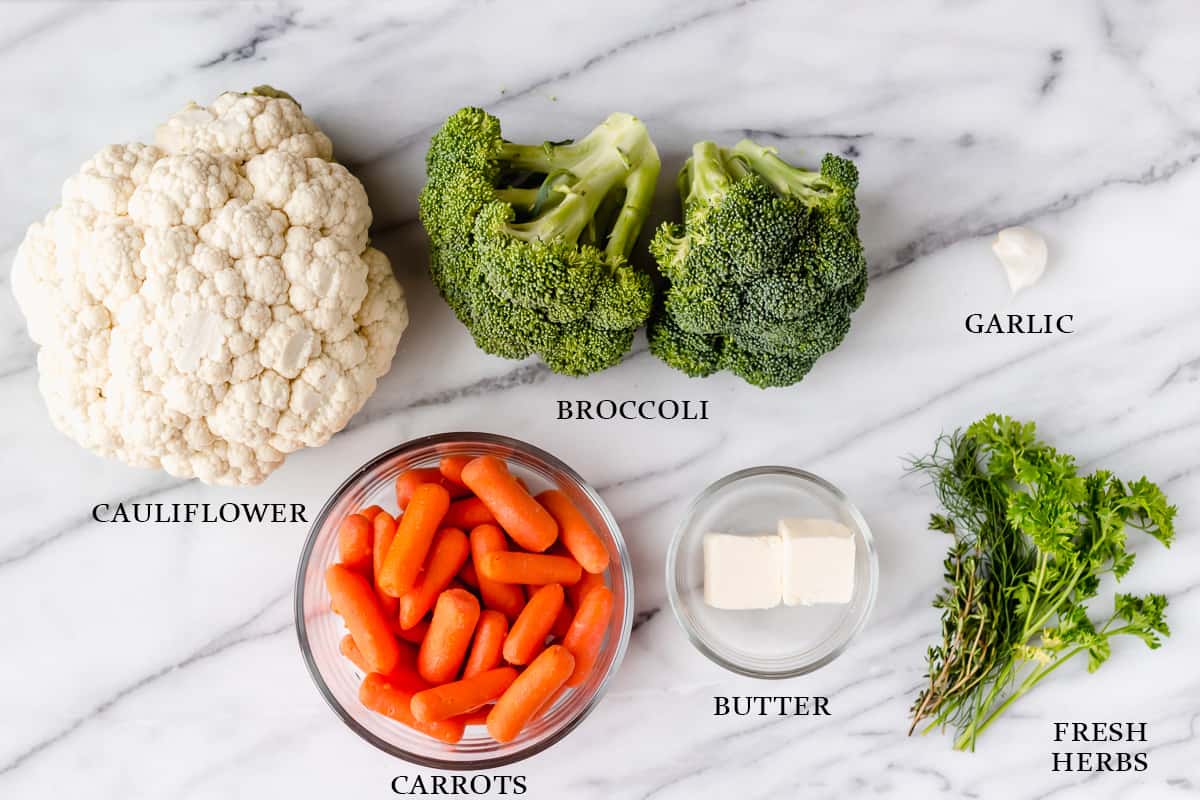 Ingredients needed to make California blend vegetables and garlic herb butter on a marble background with text overlay.