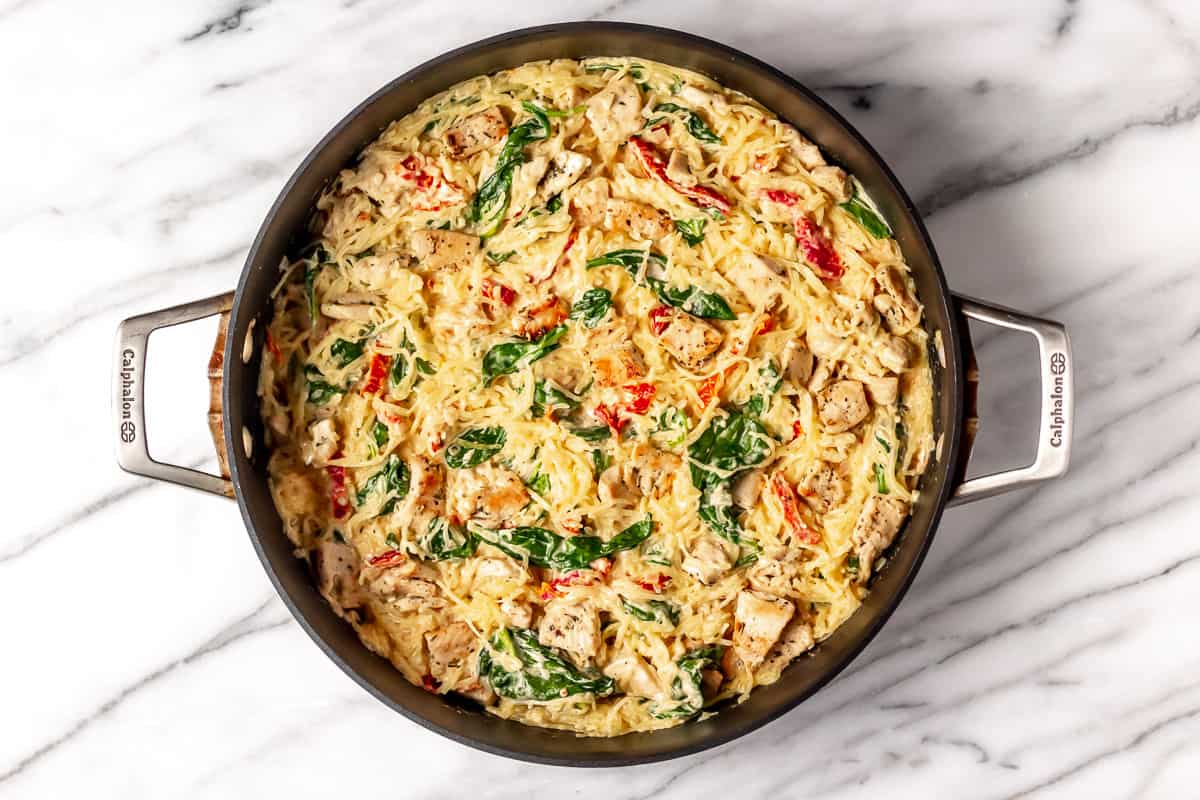 Tuscan chicken and spaghetti squash in a black skillet.