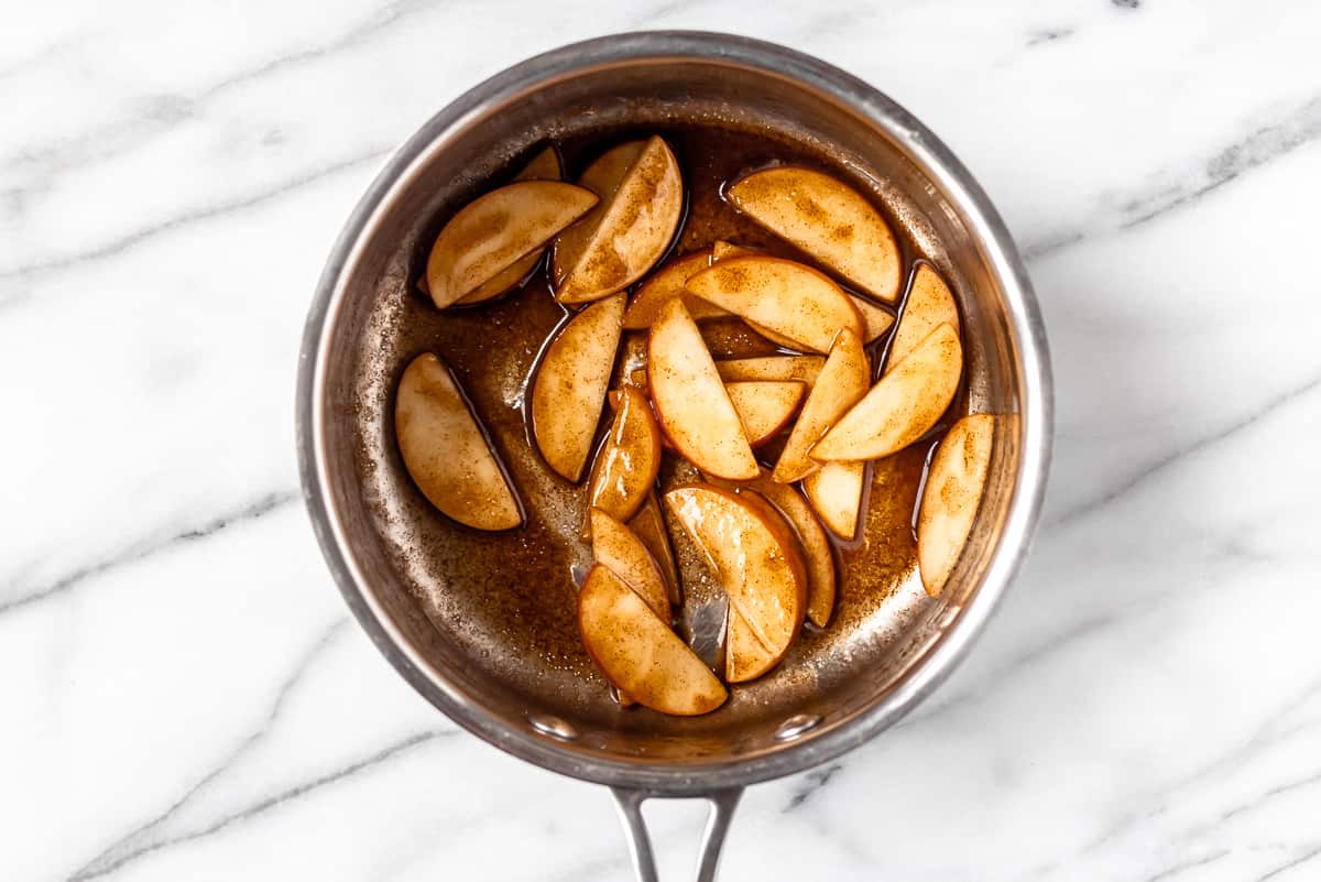 Cinnamon apple slices cooking in a sauce pan.