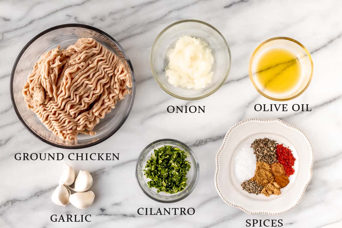 Ingredients needed to make chicken kofta on a marble background with text overlay.
