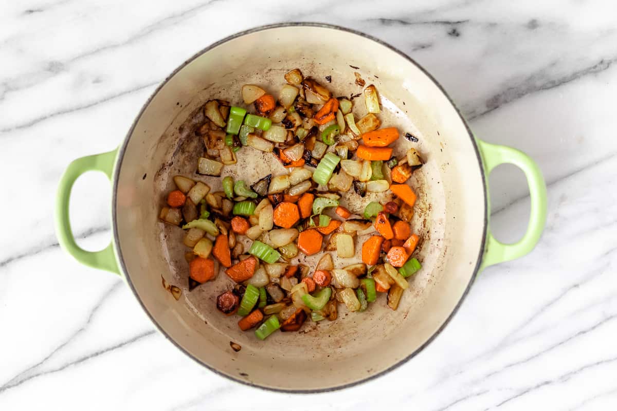 Mirepoix cooking in beef fat in a Dutch oven.