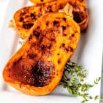 Close up of roasted honeynut squash with thyme.