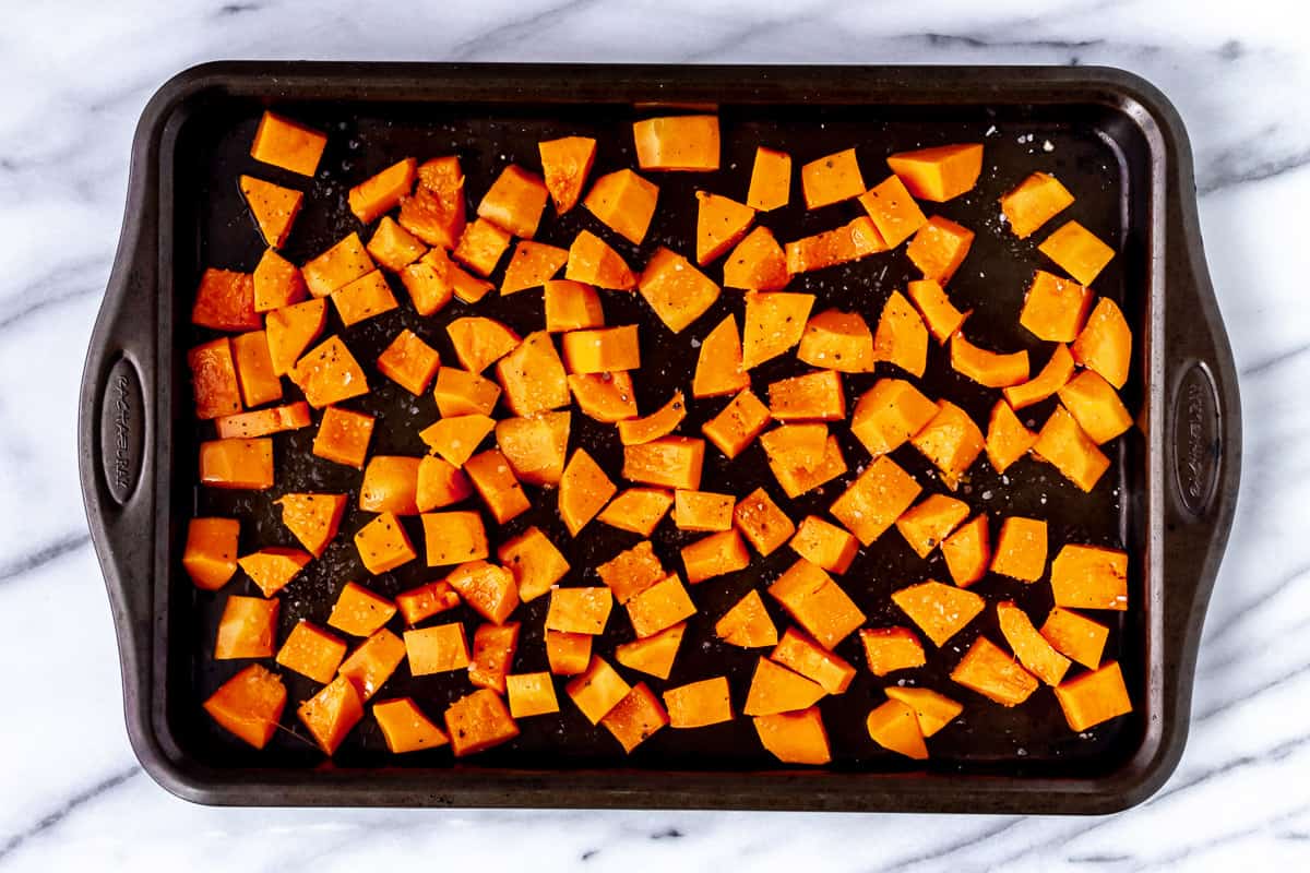Cubed honeynut squash on a sheet pan with olive oil, salt and pepper.