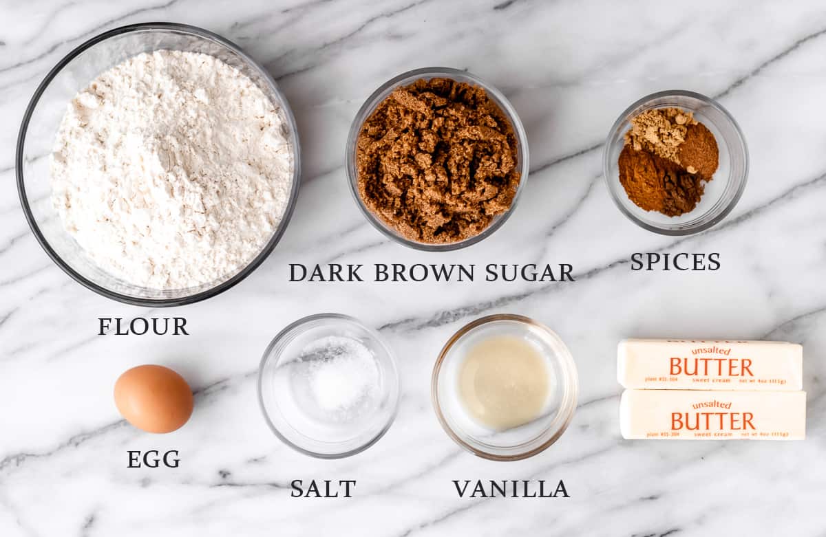 Ingredients to make gingerbread cookies without molasses on a marble background with text overlay.